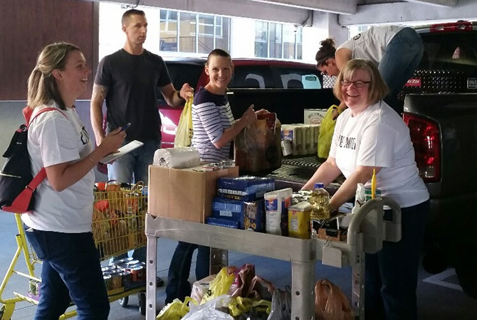 Employees from the Peoria office sorting canned goods from a food drive held to support the local community.
