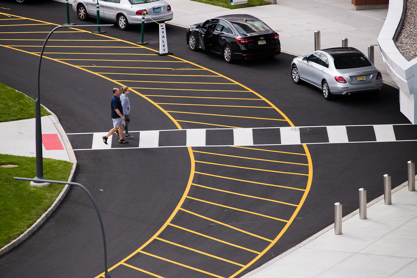 Alternating black and white marks along a narrow strip connecting two paths indicates a walkway for pedestrians. 