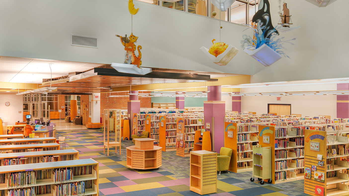The two-story exhibition space serves as a focal point for the library’s public areas, anchoring a play and reading area on the first floor of the children’s library.