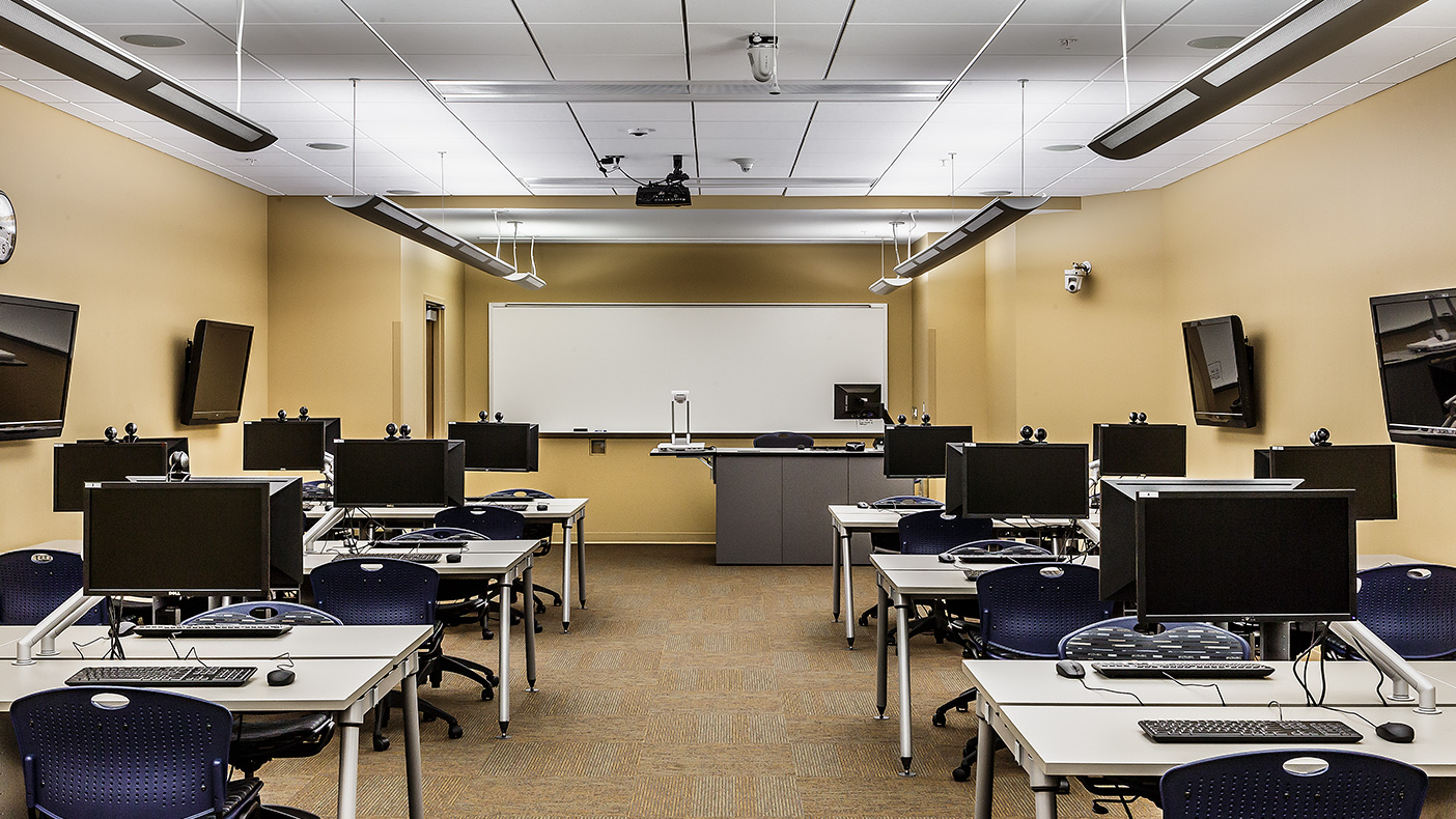 The technology room includes pods with four individual computers, as well as a central wall-mounted screen for group work. Computer monitors mounted on adjustable arms can be moved for usable tabletop space (photo courtesy Mark Ballogg).