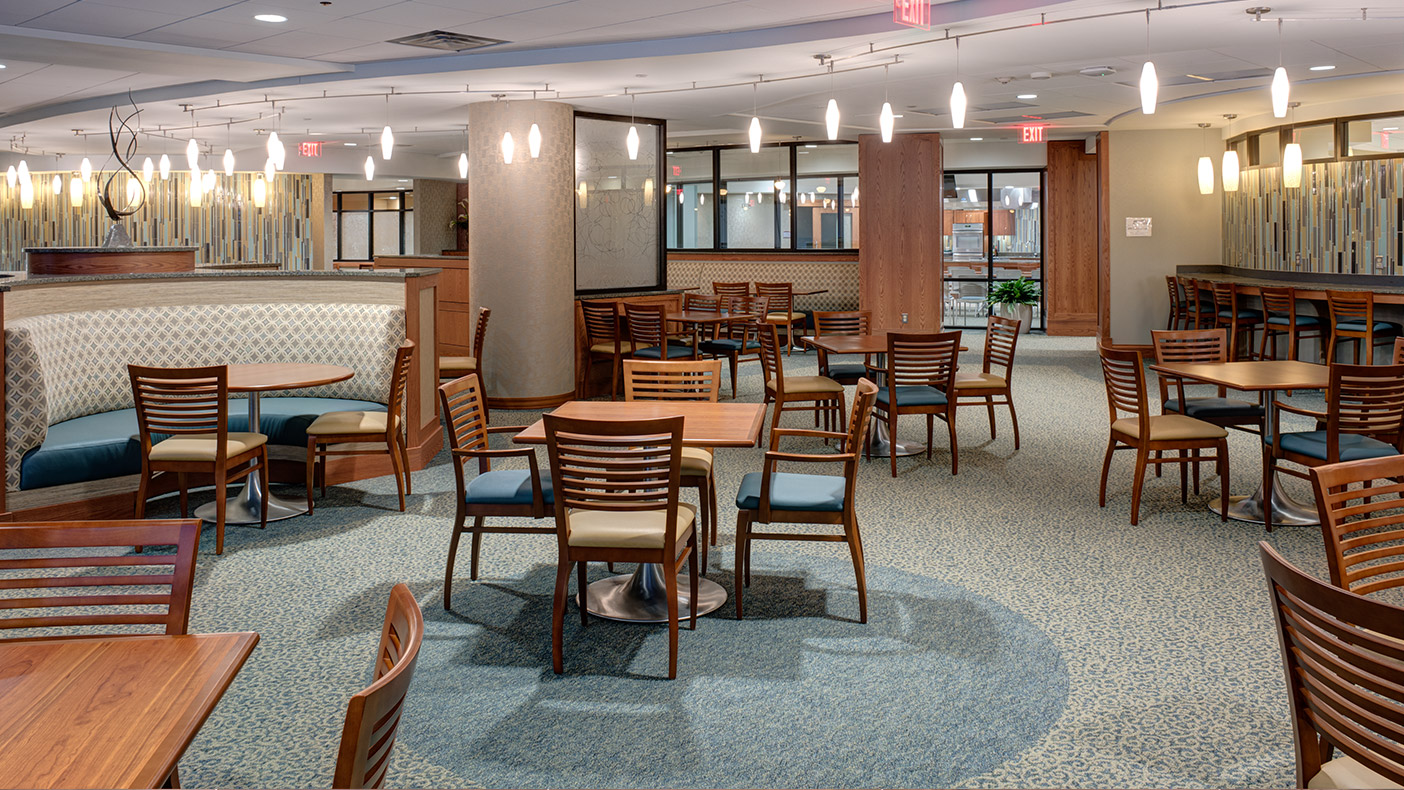 This restaurant-style dining room features circular booths, curved coffee bars, an intimate private dining room, and open tables providing patients and caregivers space to unwind and share a meal.