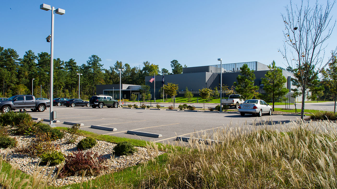 The parking lot consists of approximately 125 spaces, pedestrian crosswalks, and bike racks in close proximity to the building.