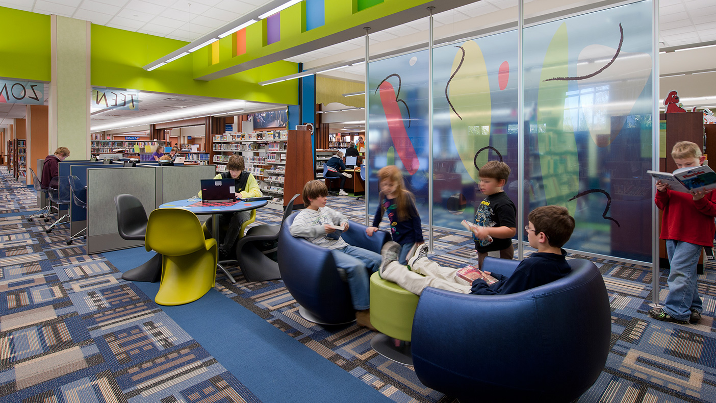 Highlights include a larger children’s area with a dedicated space—featuring a colorful rainforest theme, a comfortable reading area with fireplace, a specialized Teen Zone, and larger meeting rooms.