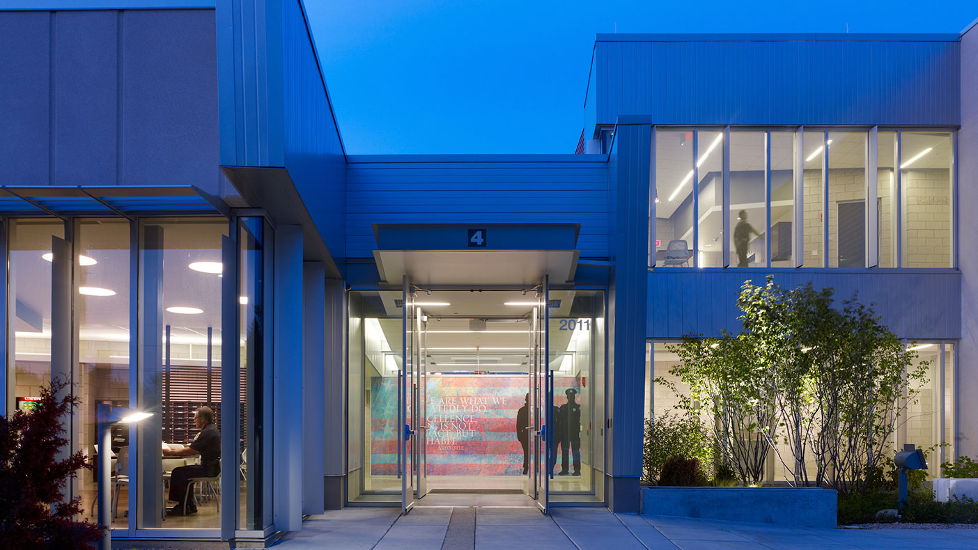 The transparent, welcoming staff entry brings officers into the heart of the department with roll call, break, vending, mailbox, and report writing areas nearby.