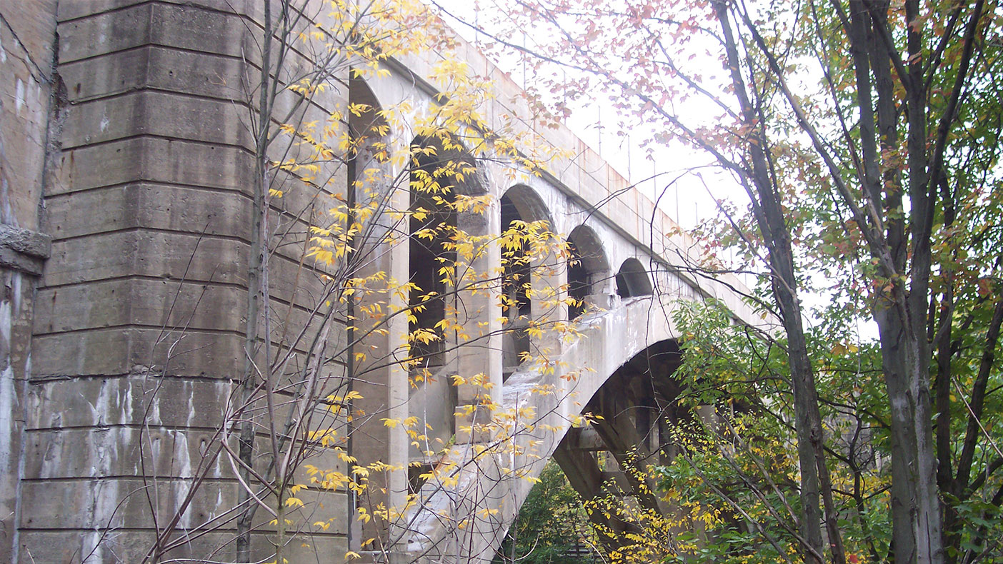 The bridge consisted of a 465-foot main span composed of four concrete arch ribs with spandrel columns supporting the deck structure while 75-foot barrel arch spans crossed roads and rails on either side.