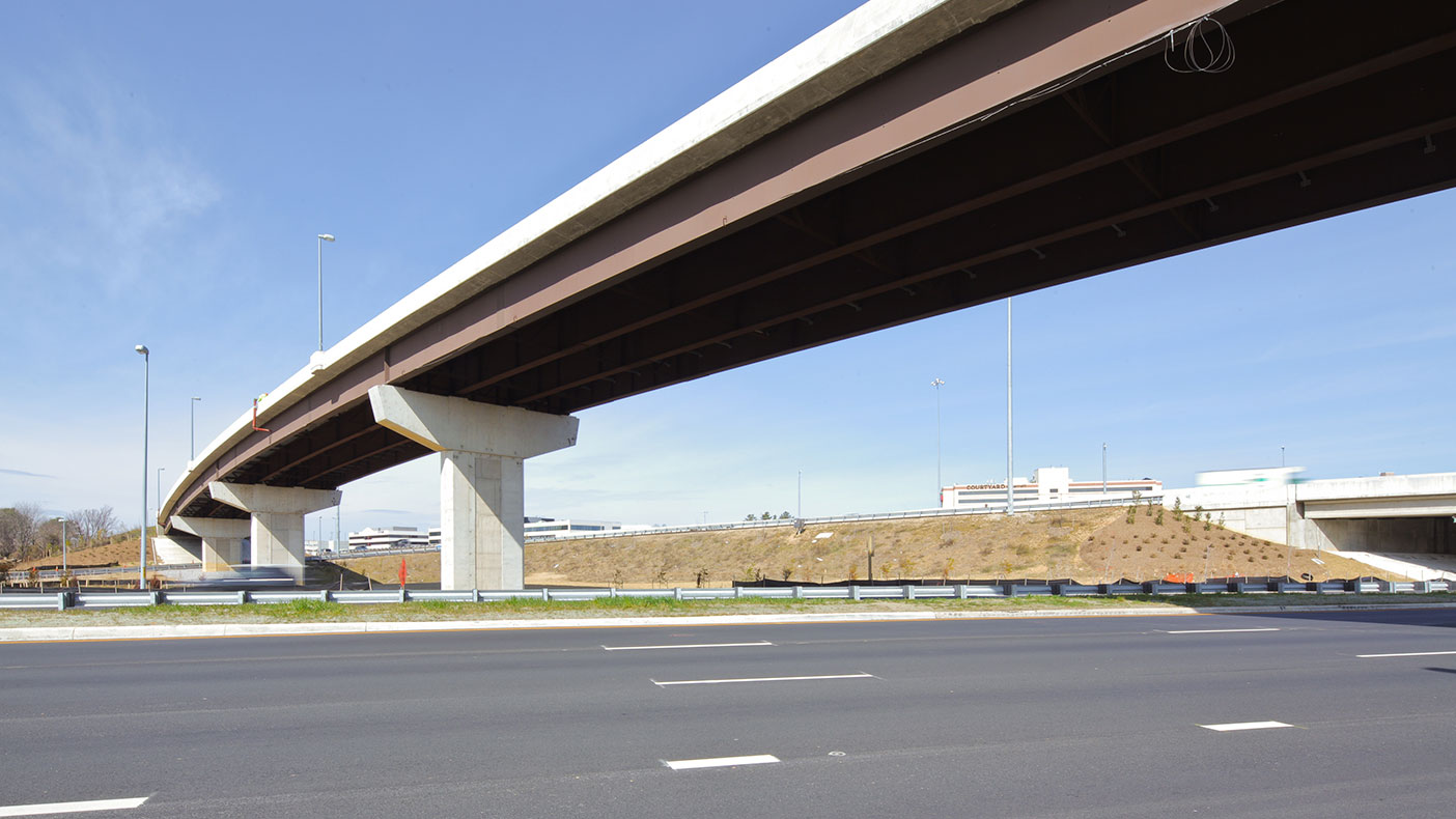 The highly constrained area with challenging soil conditions included an urban, low speed interchange, a three-level ramp bridge, and low maintenance jointless bridges.