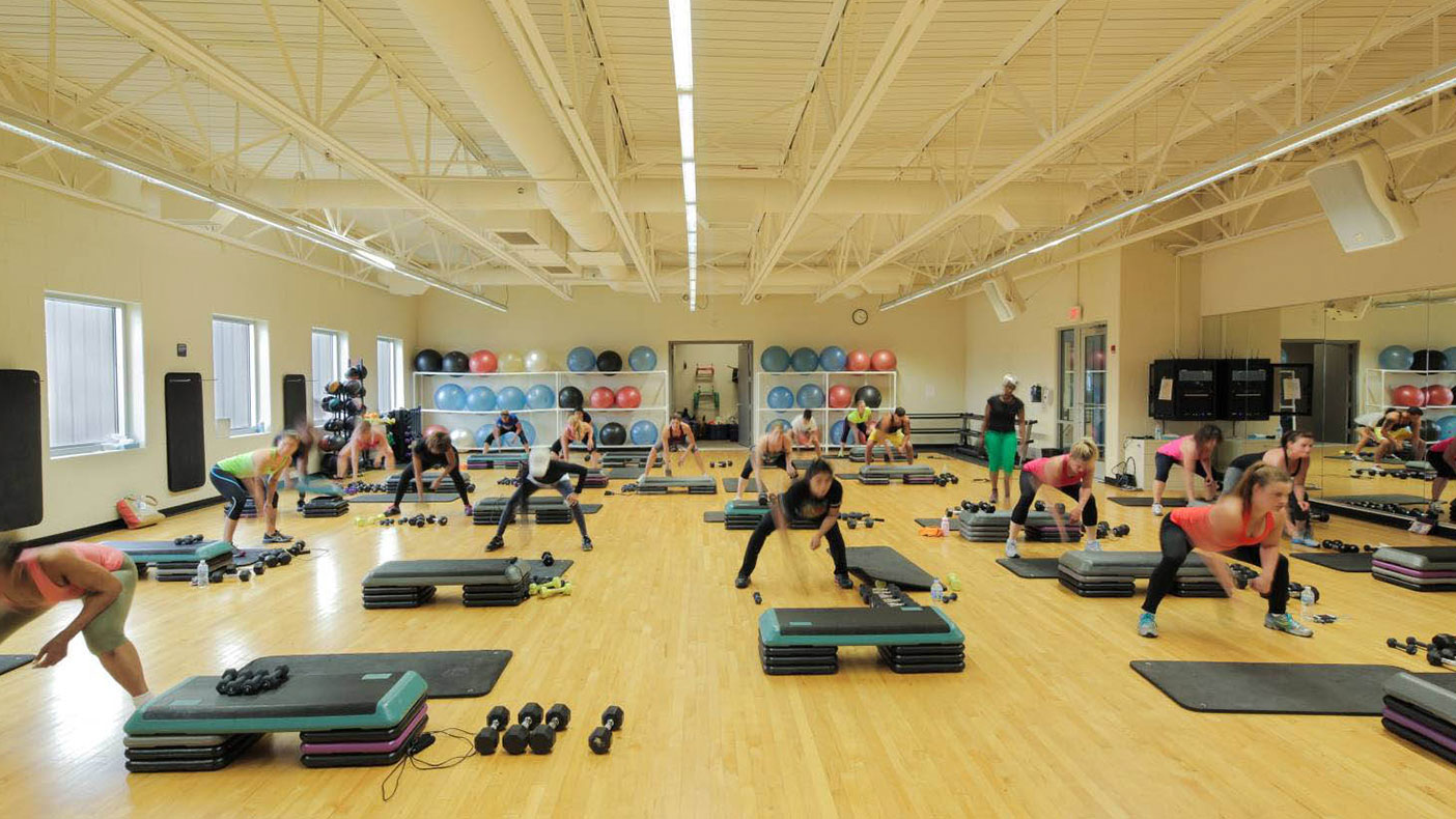 The upper level group exercise room is outfitted with a floating wood floor system, windows, storage, mirrors, and a sound system.