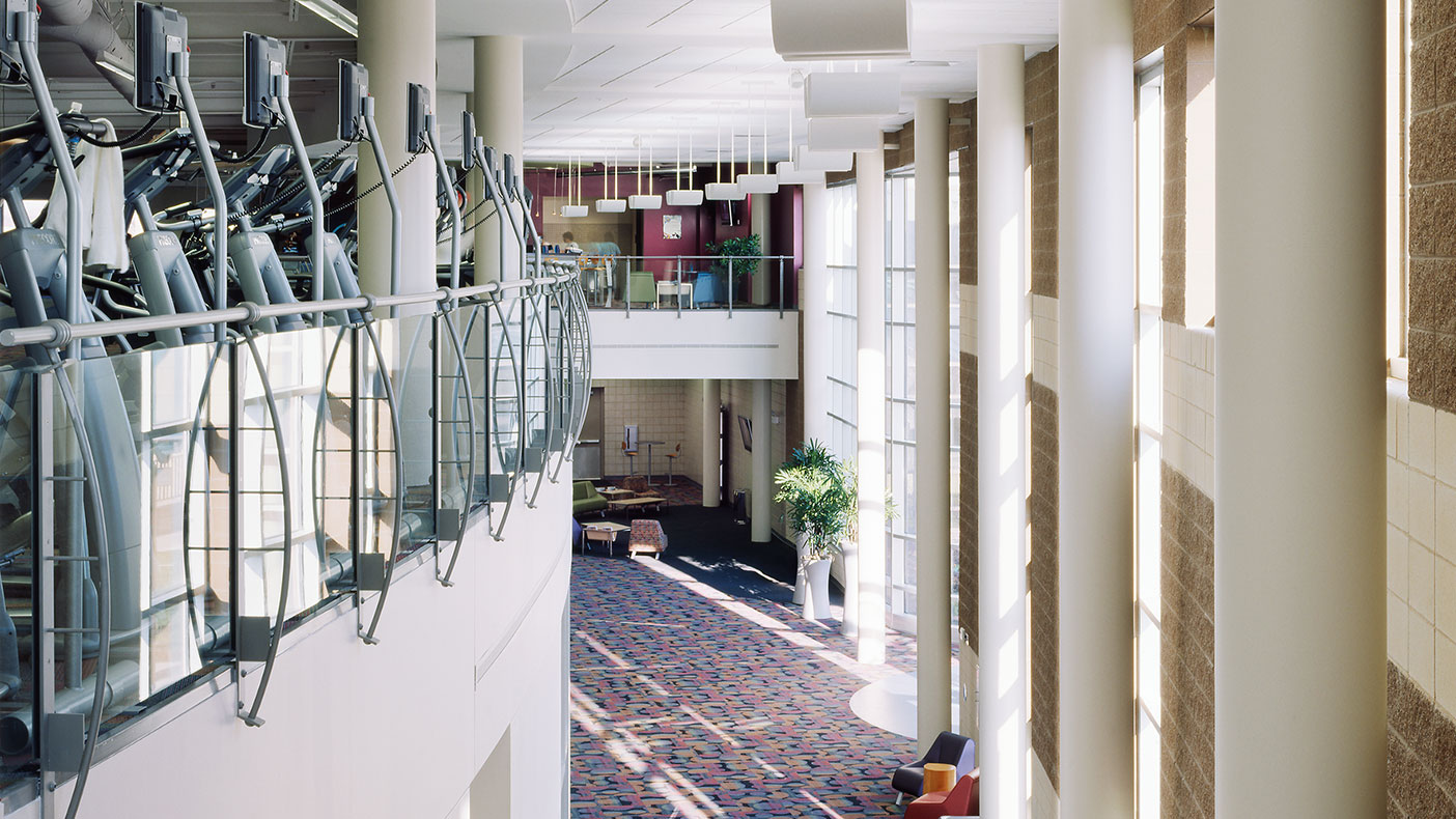 The second-level fitness area faces a number of windows and overlooks the public space below.