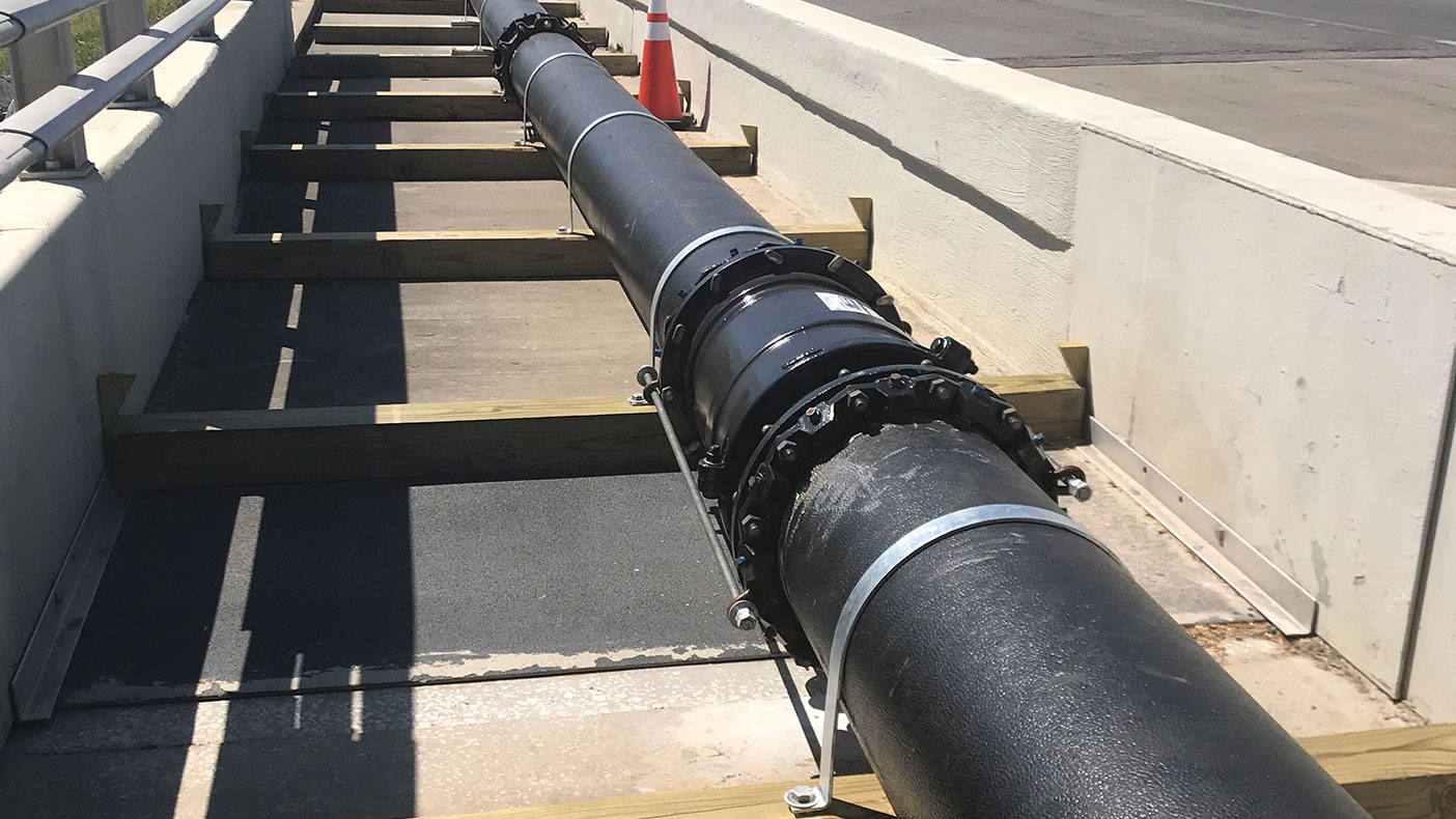 The proposed 16-inch water transmission main was connected to the existing 24-inch water main at each end of the bridge, using a 24-inch tapping saddle and valve.