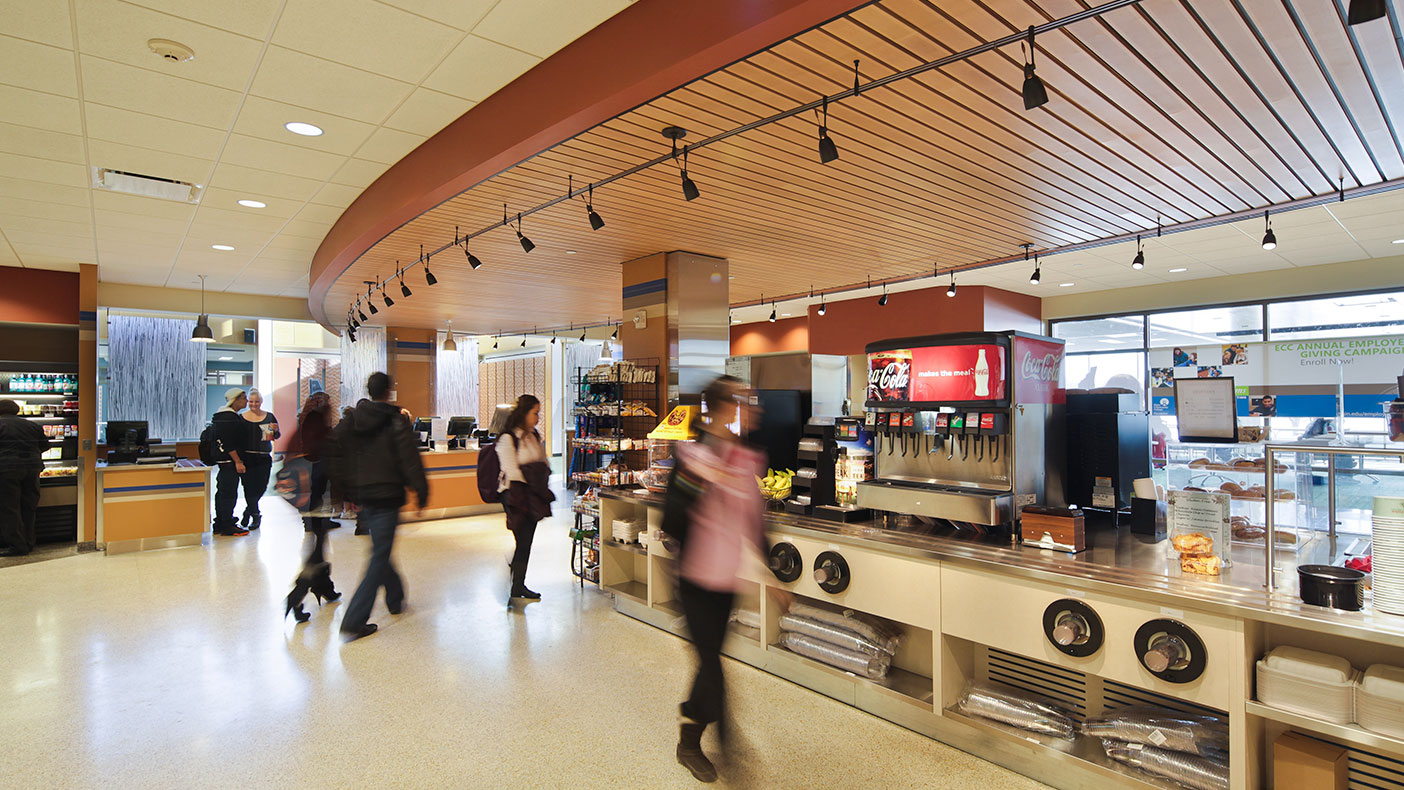 The library includes a two-story café, a 120-computer open technology lab, private study rooms, and a quiet reading room overlooking the main entry.