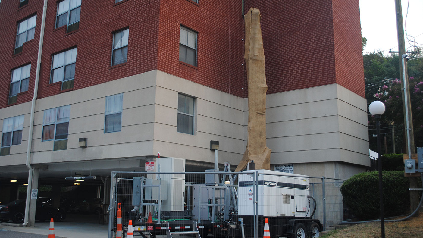 Antennas were serviced by a ground-level mobile trailer connected to the rooftop equipment through a partially erected tower and cables.