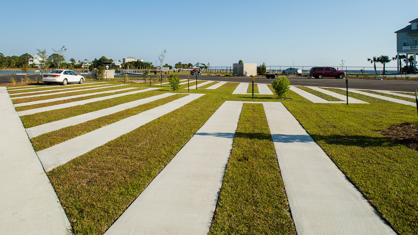 The parking area consists of asphalt drive aisles, perimeter trailer parking spaces, and a semi-pervious grassed area with concrete tire strips for the interior trailer parking spaces.