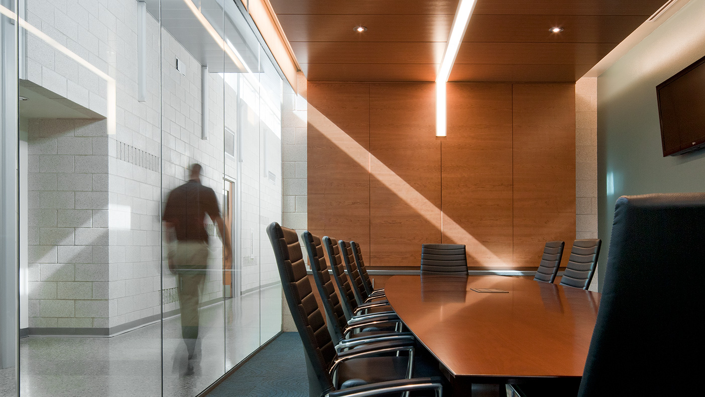 Serving as the police department’s EOC, the conference room showcases natural daylight harvesting from the corridor clerestory and includes many natural materials such as polished concrete, burnished concrete masonry unit, wood paneling, and glass.