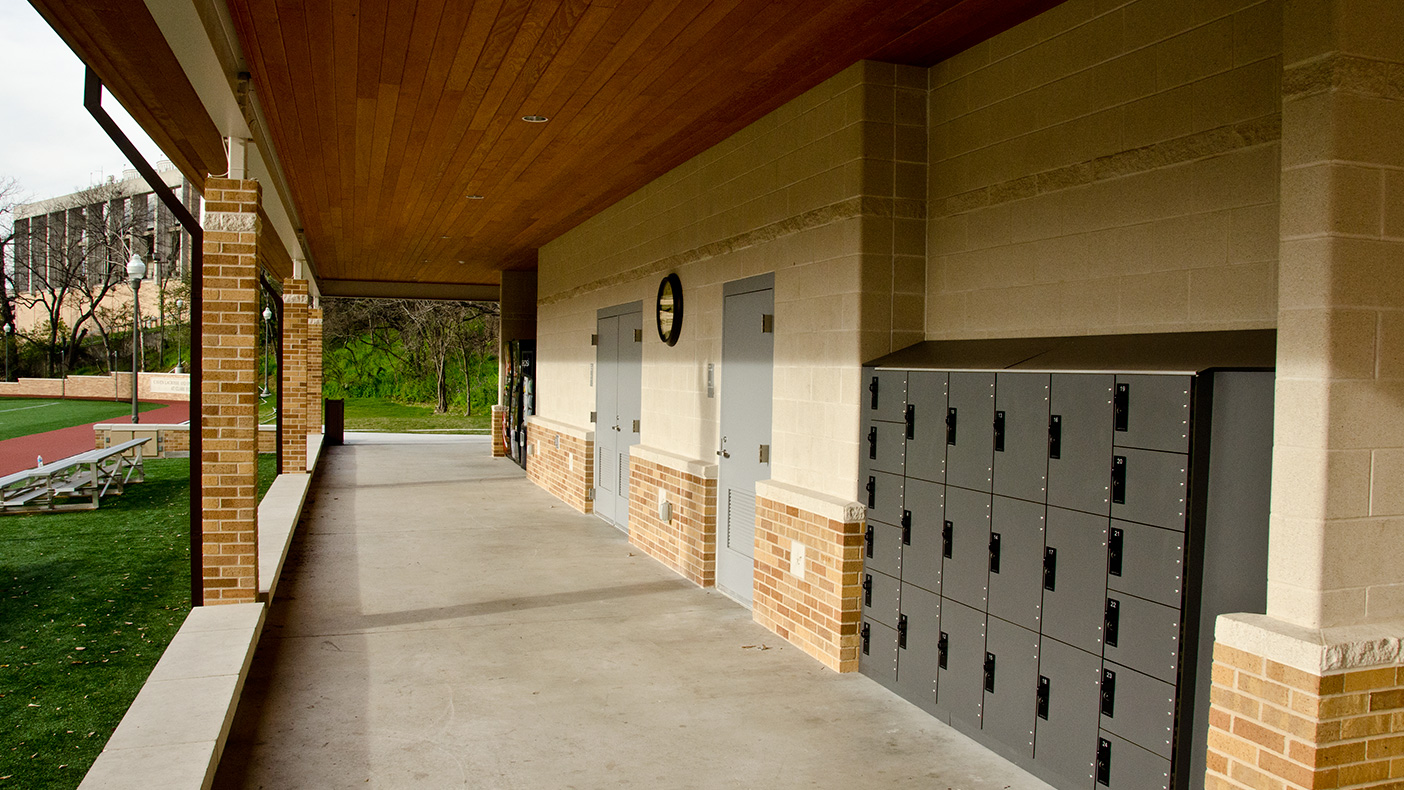 The sports center’s support building includes day-use lockers, two unisex restrooms, a filtered water bottle filling station, informal recreation equipment and sports club gear, and storage areas for maintenance equipment.