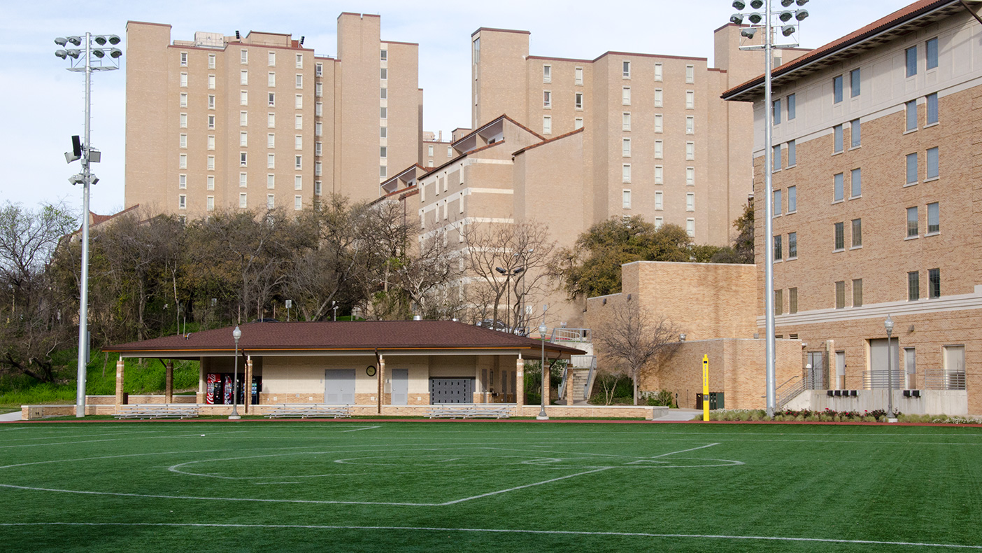 The exterior of the support building is designed to be compatible with the adjacent residence halls while also serving as a backdrop for the field.