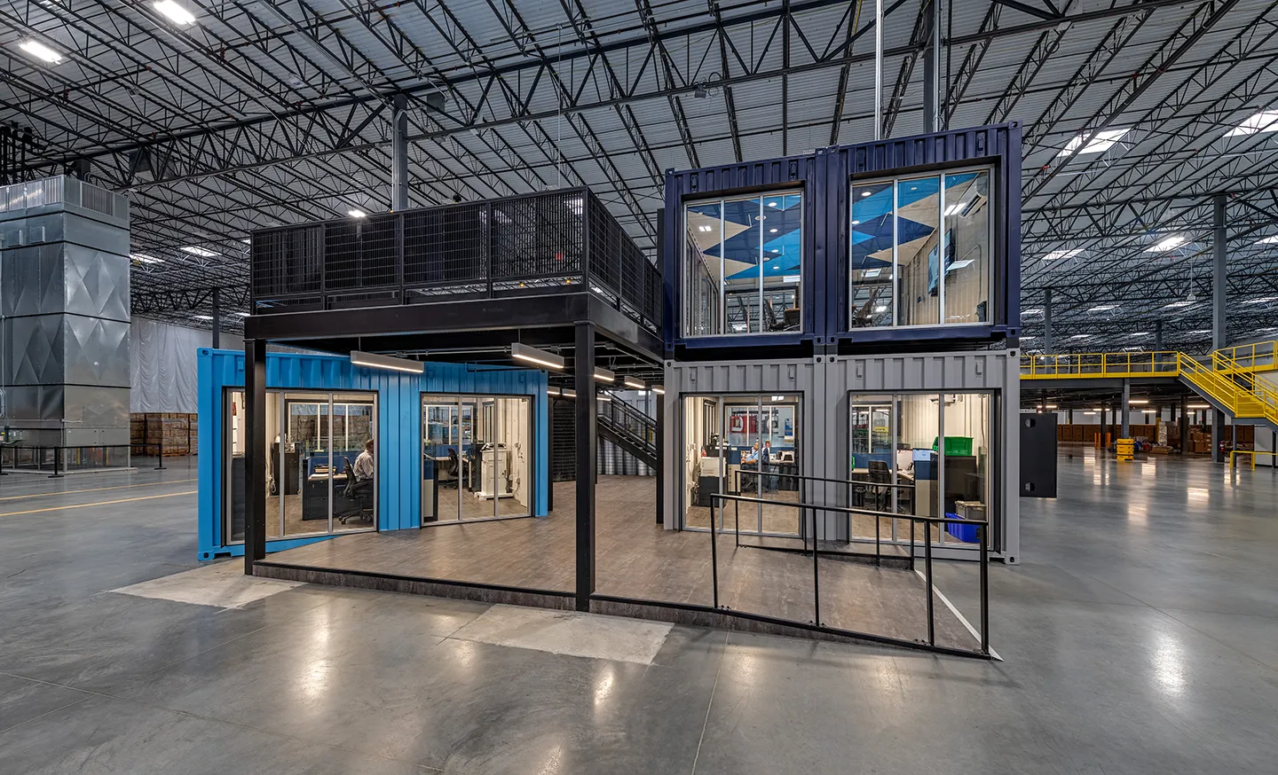 The client had a vision of using shipping containers to add office space, restrooms, and conference space to the large warehouse.