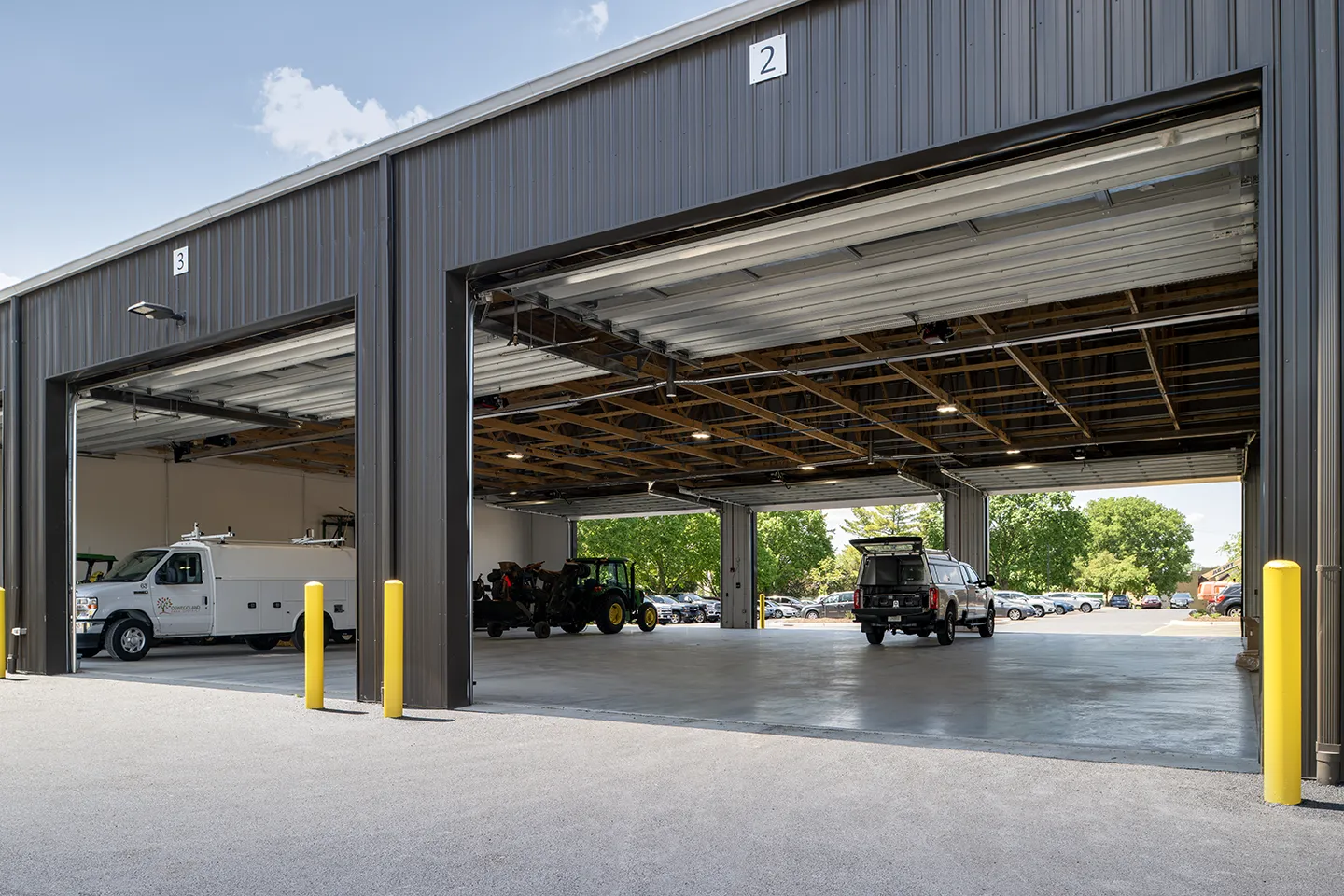 The maintenance side of the facility houses a dedicated wood shop, vehicle wash bay, maintenance equipment and vehicles, and a separate recreation storage bay with an overhead door.